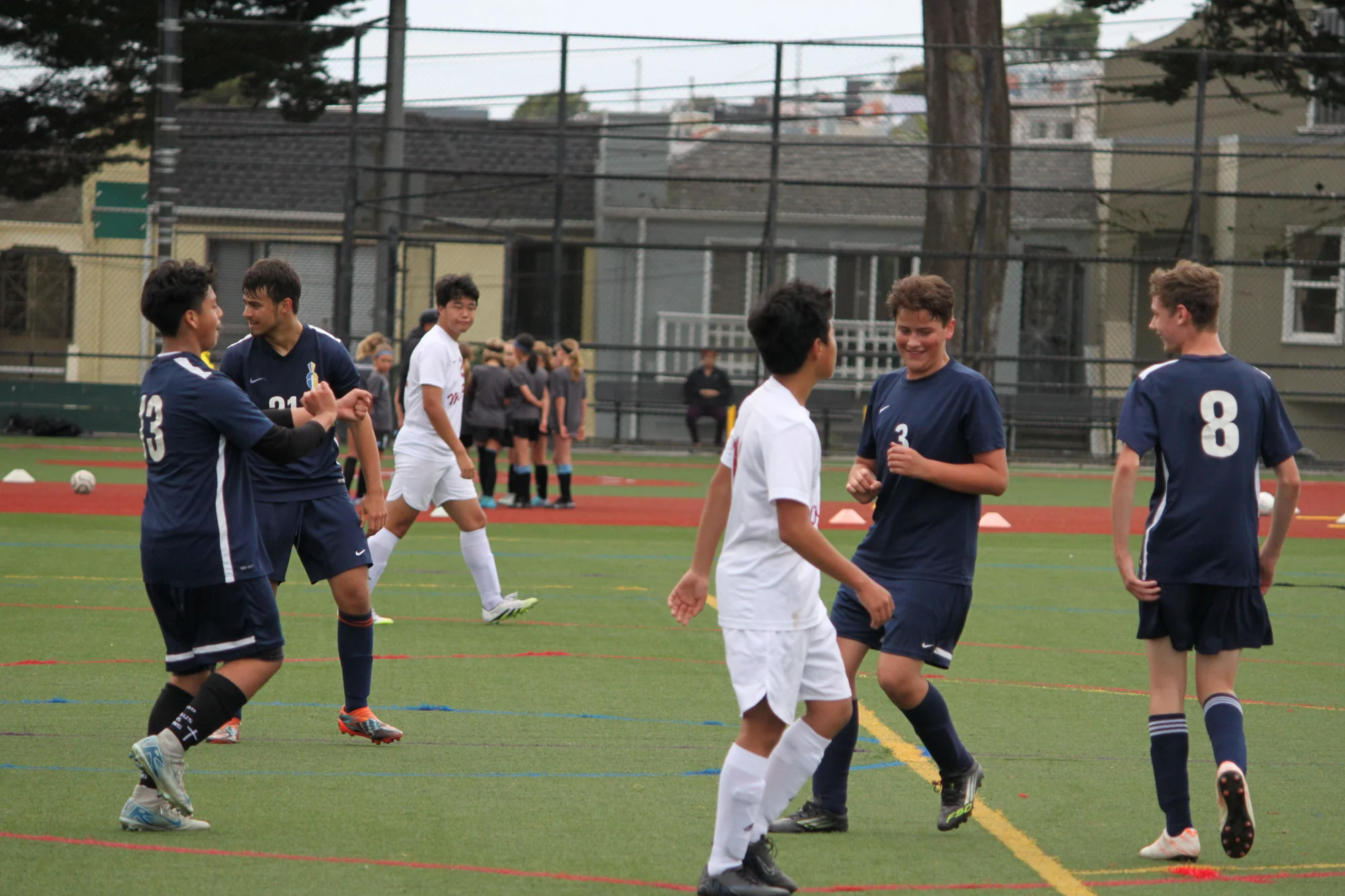 Trojans soccer players smiling and applauding together on the field