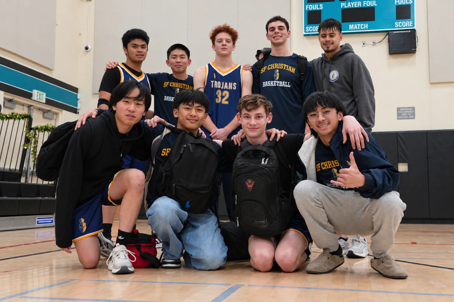 The basketball team posed arm in arm on the court after a game