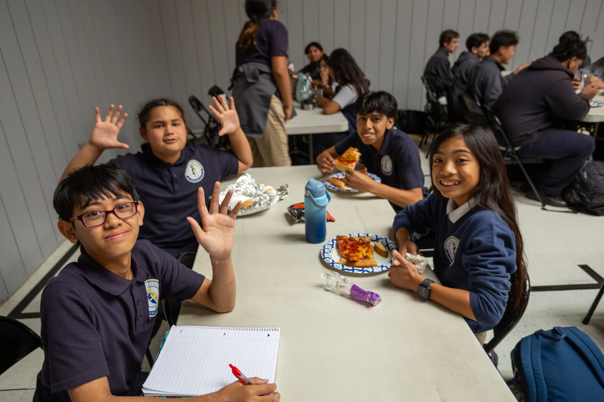 Students share lunch together at a cafeteria table