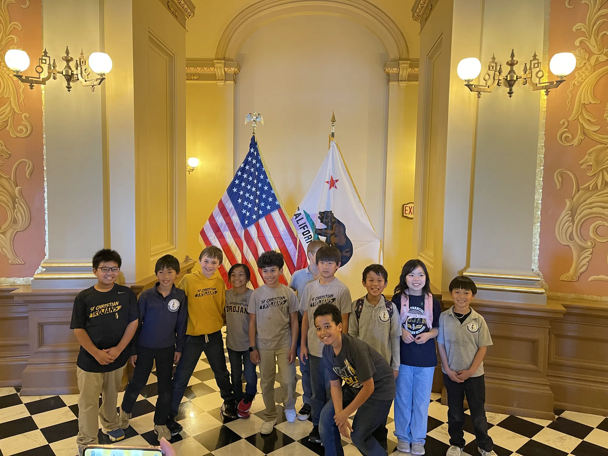 Fourth graders at the California State Capitol with the US and state flags