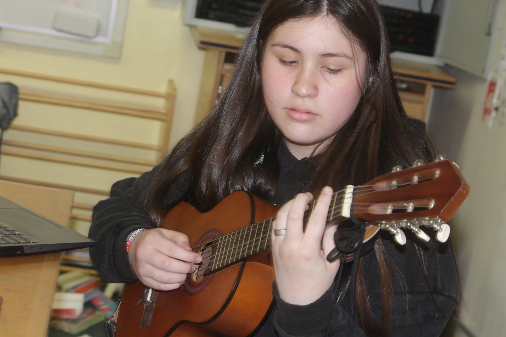 A high school student focused on classical guitar practice