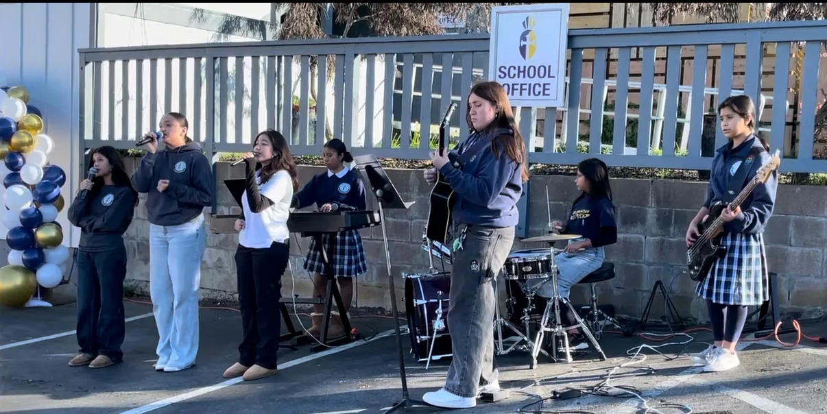 The high school praise band performing outdoors by the school office