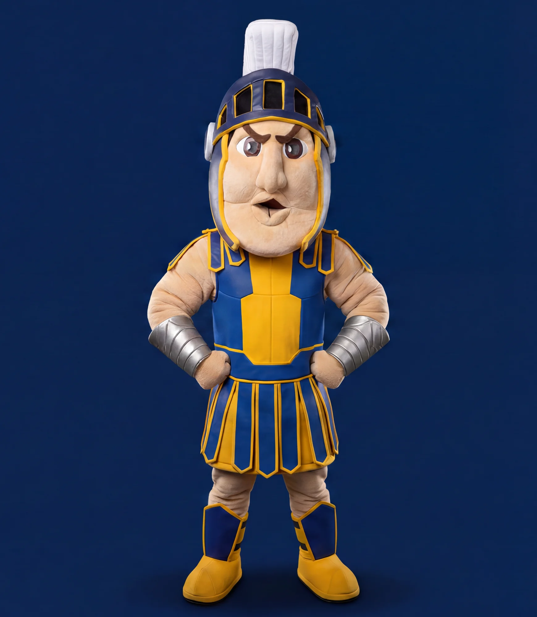 Troy, the SFC Trojan mascot, standing in blue and gold armor with his hands on his hips