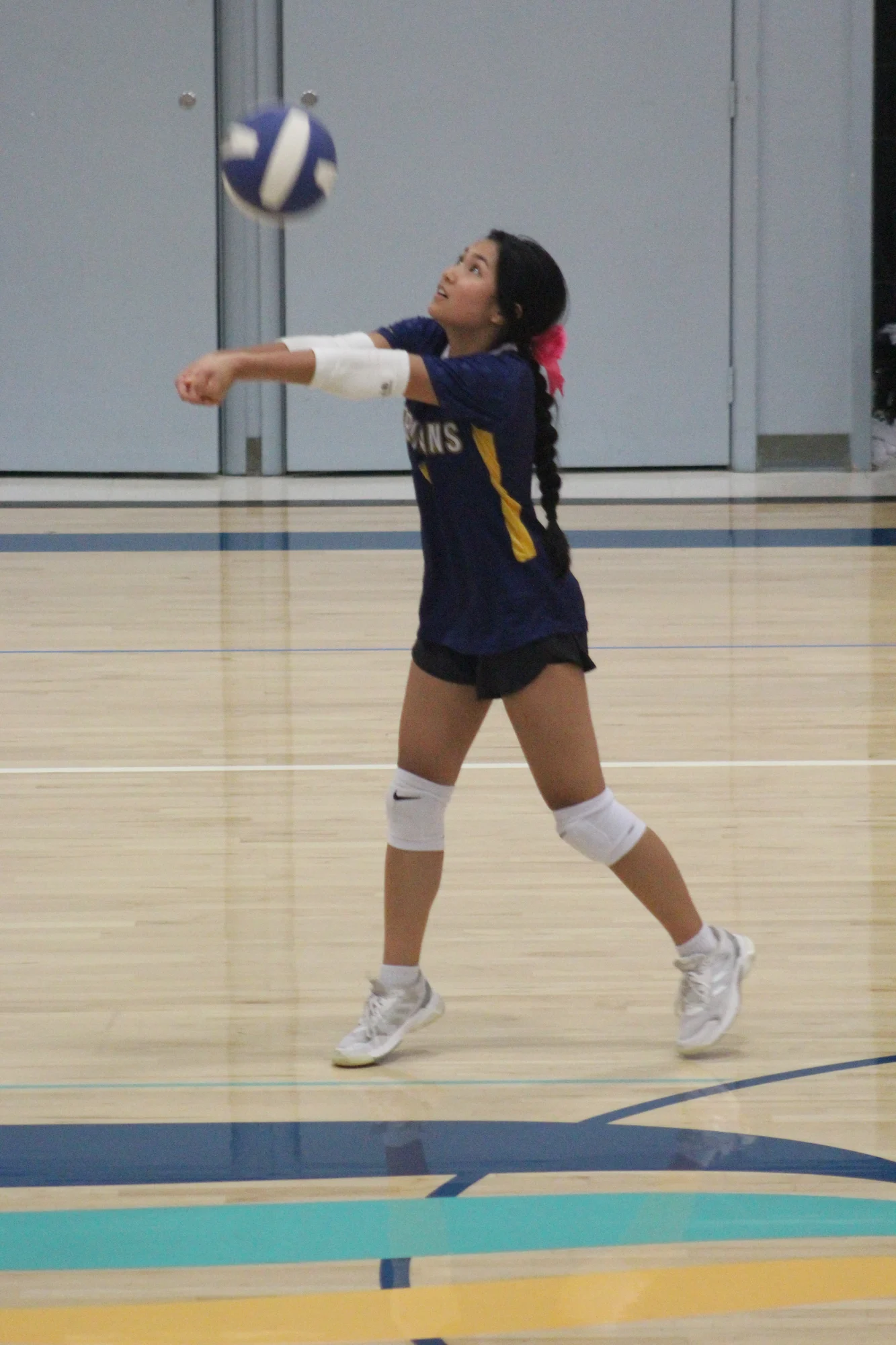 A Trojans volleyball player reaching out to make a forearm pass